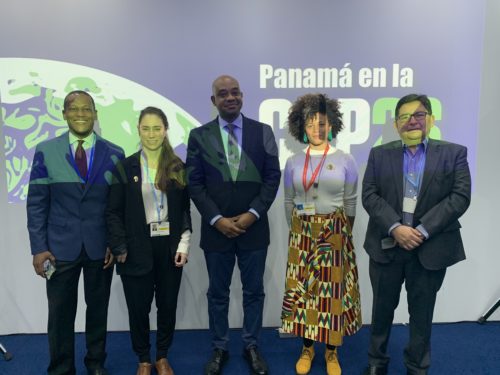 Five people stand in front of a sign that says Panama en la COP26